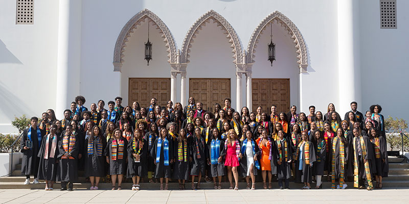 LMU graduates pose in front of Sacred Heart Chapel after Kente Graduation 2022