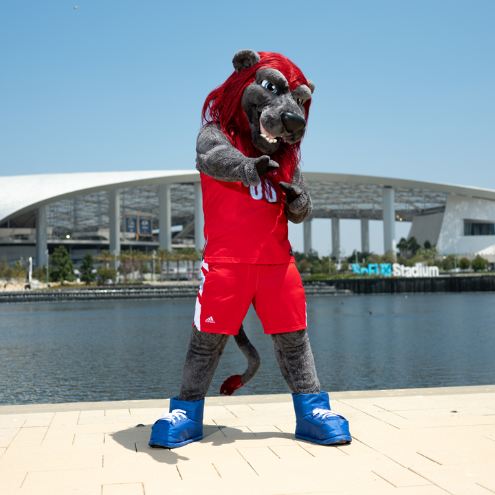 Iggy the Lion standing in front of Sofi Stadium