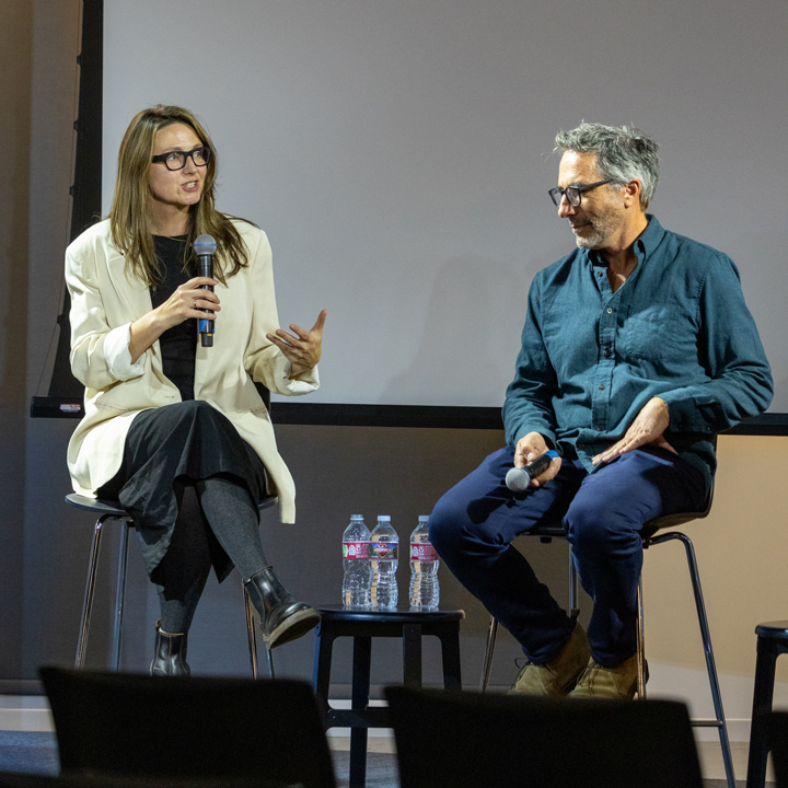 Two people conversing on a stage