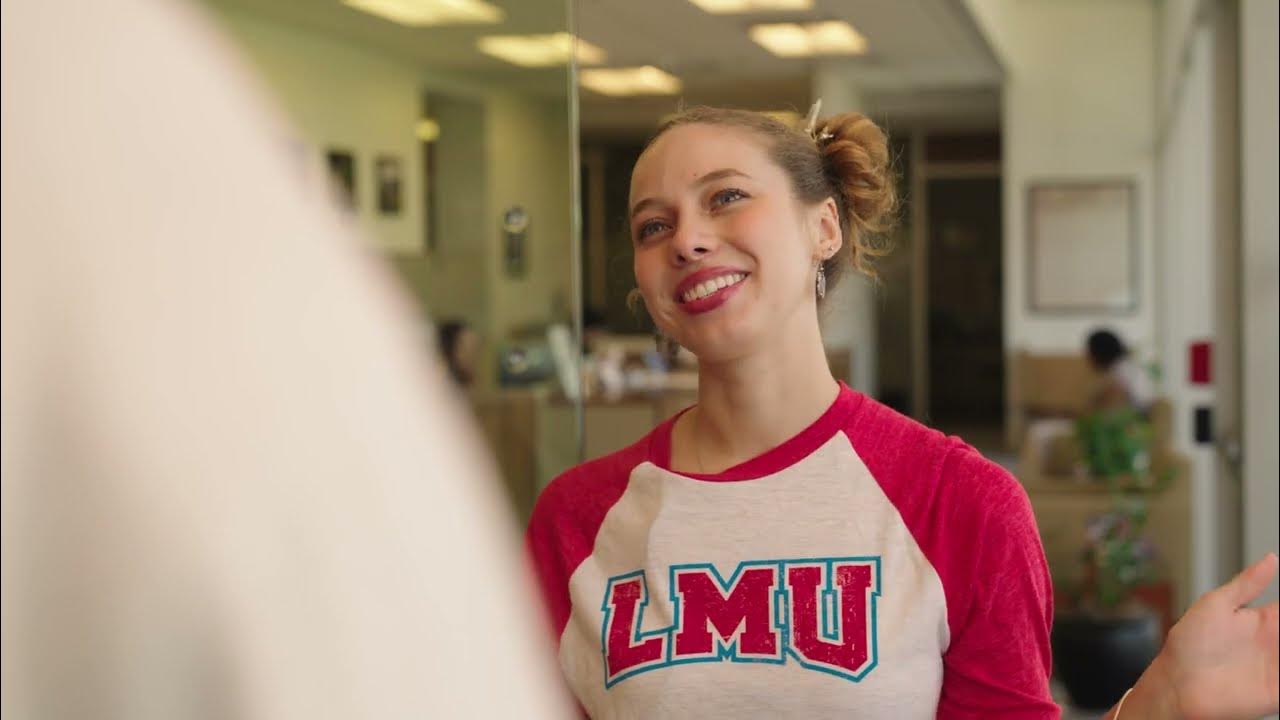 An alum wearing an LMU Branded shirt and smiling