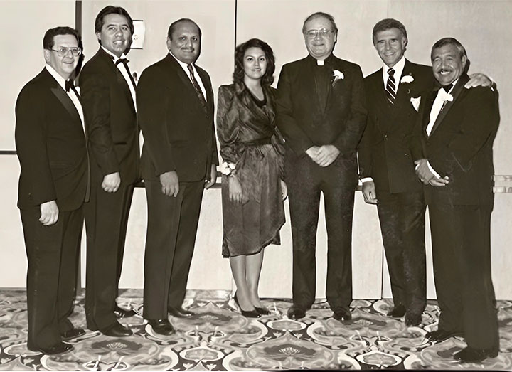 Black and white photograph of James N. Loughran, S.J. with members of the Mexican American Alumni Association.