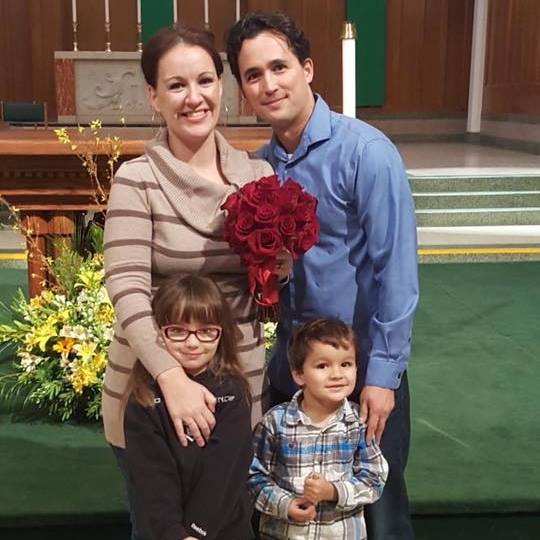 Two parents and two kids in front of altar
